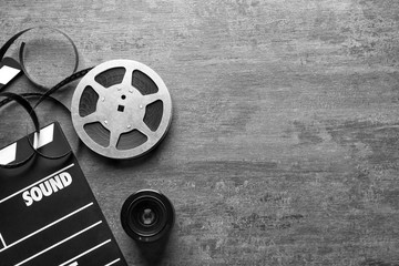 Movie clapper and reel on grey background, top view