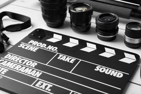 Movie clapper and lenses on light background, closeup