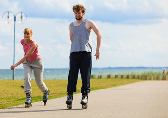 Youngsters together skating in seafront park.