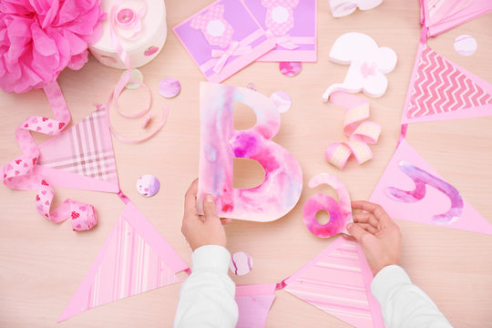 Woman preparing decorations for baby shower party on table