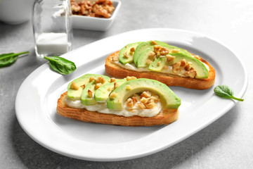 Plate with tasty fresh bruschettas on table