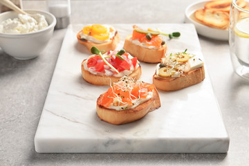 Marble board with tasty fresh bruschettas on table