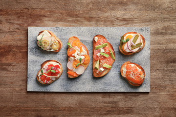 Board with tasty fresh bruschettas on table