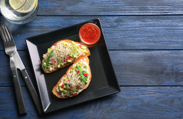 Plate with tasty fresh bruschettas on table