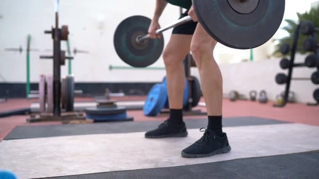 Fitness weightlifting man training Bent-Over Row aka Bent Over Row aka Barbell Row. Fit male athlete strength training working out in outdoors fitness gym living healthy active lifestyle.