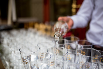 young waiter pouring water in party