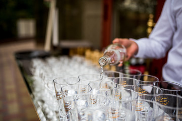 young waiter pouring water in party