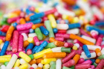 Closeup of a pile of colourful sugar sprinkles (cake decor), side view