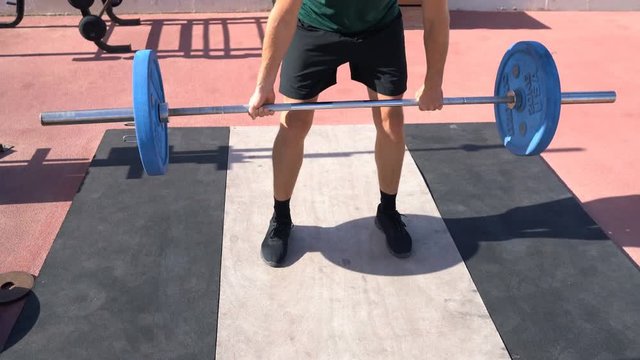Deadlift - Weightlifting fitness man bodybuilding or powerlifting at outdoors gym. Bodybuilder doing barbell weight workout deadlift with heavy bar.