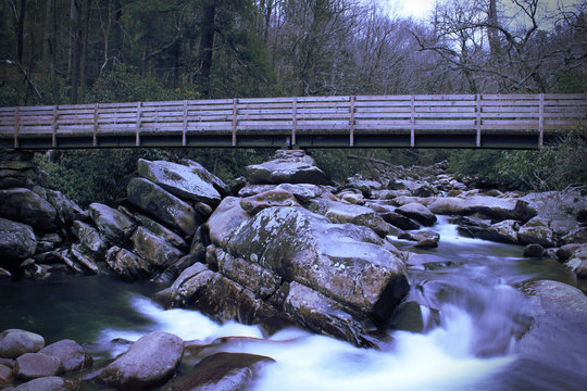 Slow Shutter Speed Motion Photography of a Wooden Bridge over a Rushing Waterfall