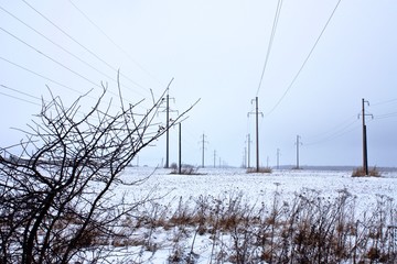 power lines out to the horizon in a snowy winter field