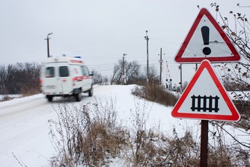 the ambulance rushes past the sign railway crossing