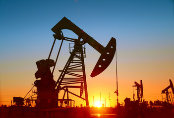Is operation of the pumping unit in oilfield sunset, close-up