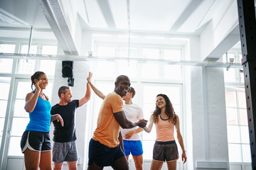 Friends high fiving together after a gym workout