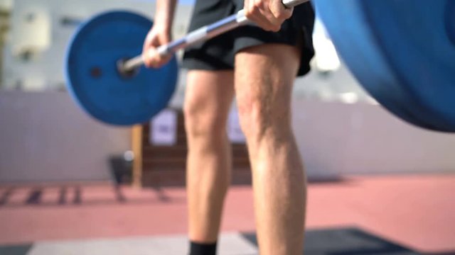 Fitness man doing Deadlift. Weightlifting fitness man bodybuilding or powerlifting at outdoors gym. Bodybuilder doing barbell weight workout deadlift with heavy bar.