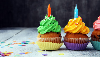 Tasty cupcakes on wooden background. Birthday cupcake in rainbow colors