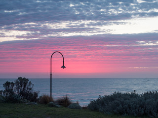 Pink sky over the St Kilda shoreline in Australia.
