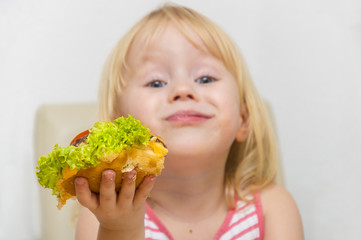 Happy hungry girl eating healthy vegan burger.