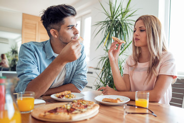 Young couple enjoying eating pizza.