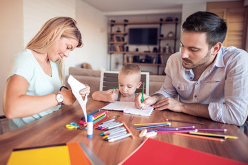 Young parents with young child draw