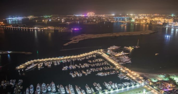 DUBAI, UAE – MARCH 2016 : Timelapse of Dubai Harbor at night with boats moving and cityscape in view