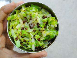 Holding bowl of cabbage and flaxseed salad