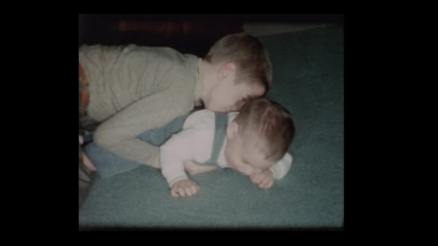 1960 Little boy plays lovingly with baby brother