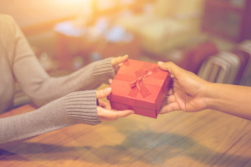 Woman hands receiving package gift box from a man - delivery and courier concepts,preparing gifts...