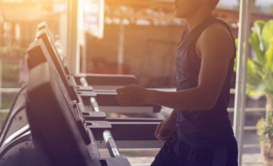 Obraz premium Electric treadmills,People running in machine treadmill at fitness gym,asian man exercising ,health care sport concept,selective focus,vintage color,in the morning