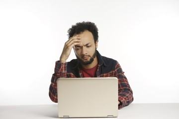 young African-American man on laptop computer with emotions