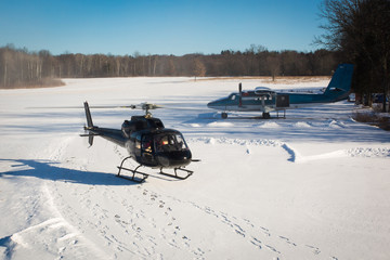 solo black helicopter in blue skies with snow