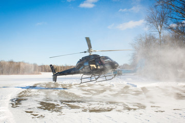 solo black helicopter in blue skies with snow