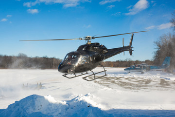 Naklejka premium solo black helicopter in blue skies with snow