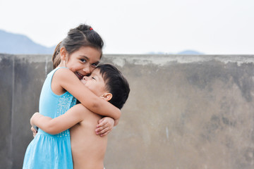 Little latin siblings hugging.