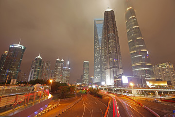 Obraz premium the light trails on the modern building background in shanghai china