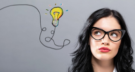 Light Bulb with young businesswoman in a thoughtful face