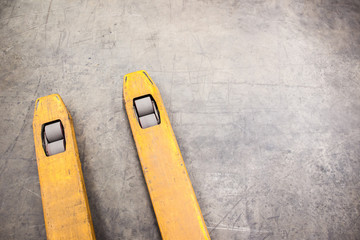 Old yellow fork lift paddles in the warehouse close up.