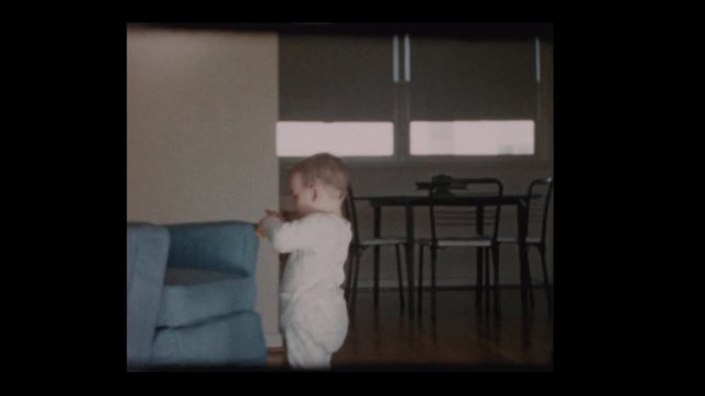 1960 Cute little boy wandering around living room