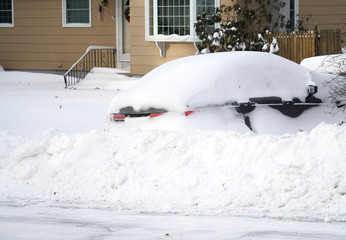 Car on the driveway buried in snow after blizzard