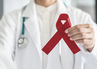 Burgundy ribbon awareness in doctor hand for multiple myeloma cancer, adults with disabilities...