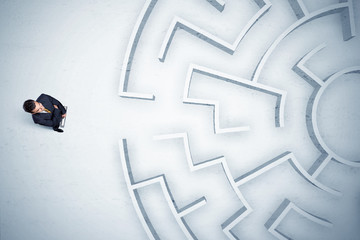Business man looking at circular maze with nowhere to go