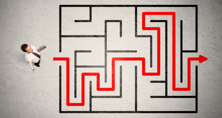 Lost businessman found the way in maze with red arrow