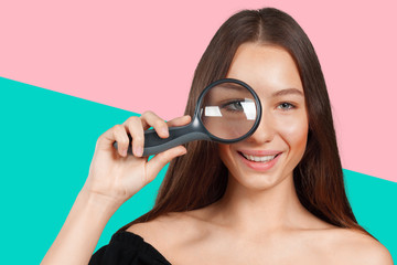 girl looking through a magnifying glass