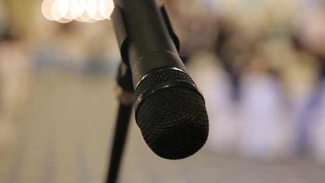Close-up of microphone in concert hall or conference seminar room background, copy space.