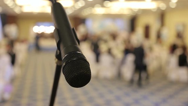 Close-up of microphone on stage at the conference, or celebration in the restaurant. Blurred background.