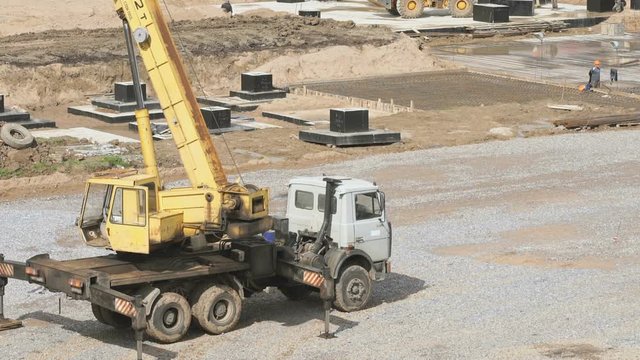 Construction site in summer season. Mobile construction crane on wheels outdoors