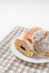 zweieinhalb 'Berliner' Pfannkuchen auf weißem Teller und Handtuch