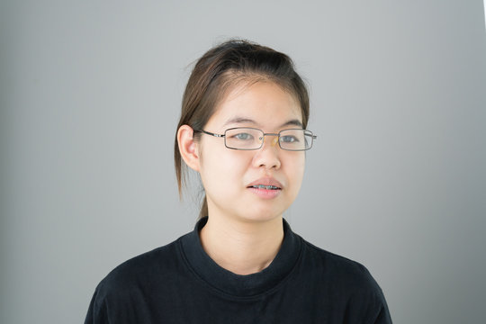 portrait of smiling asian young women put on the braces. on a gray background gives a soft light.
