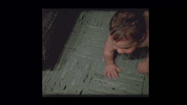 1960 Cute little boy in diapers plays to camera