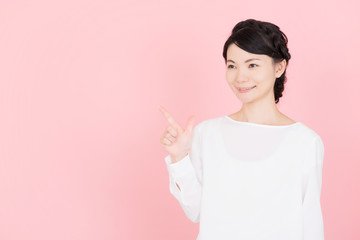 余白を指差す若い女性